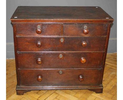 A George III oak chest, the rectangular top over two short and three long drawers with wirework escutcheons and knop handles 