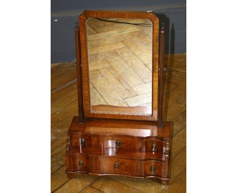 A reproduction mahogany toilet mirror, the rectangular plate within tapering horns over a stepped six drawer base, on bracket