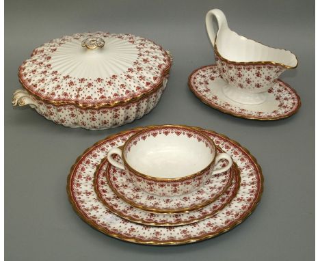 A Spode red Fleur De Lys dinner service, Y7481. Comprising twelve dinner, tea and side plates, eleven twin handled cups and t