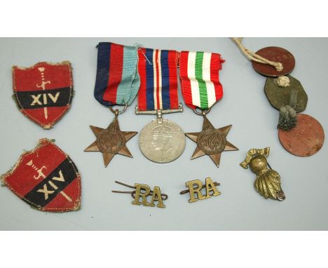 A group of three second war medals, three dog tags, two named W Tattersall, two 14th Army division cloth badges and three Roy