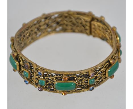 A vintage 1920s Czech filigree gold tone hinged bangle with coloured rhinestones and glass faux jade cabochons with box clasp