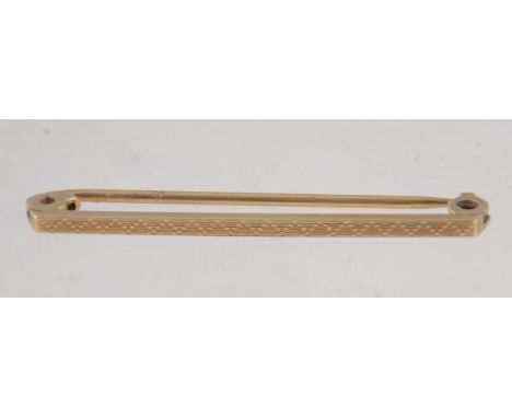 A 9ct gold tie bar pin with chased pyramid decoration. Marked 9ct. Tests 9ct gold. Measures 4cms. Weighs 1.4g