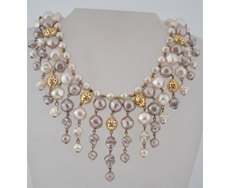 A vintage faux pearl bib necklace in shades of white and oyster grey with gold tone filigree beads and hook fastening. Measur