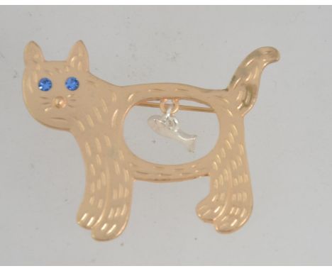 A vintage yellow metal figural brooch in the form of a cat with dangle fish, blue rhinestone eyes and roller clasp. Measures 