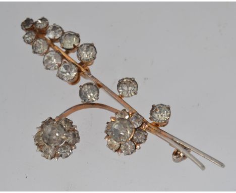 A vintage white metal flower spray brooch set with clear rhinestones and roller clasp. Measures 7cms.