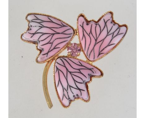 A vintage yellow metal modernist brooch with foliates and central pik rhinestone with roller clip clasp. Measures 4cms.