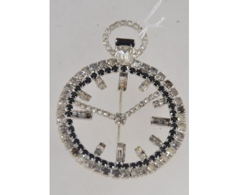 A vintage silver tone figural brooch in the form of a pocket watch with channel set rhinestone decoration and roller clip cla