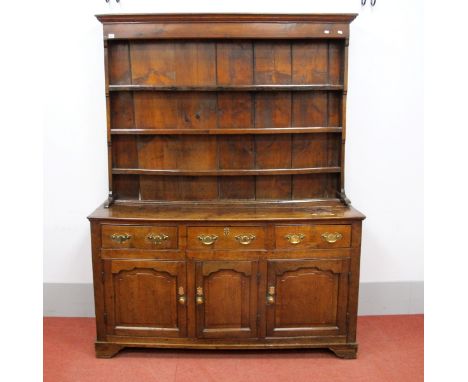 An XVIII Century Joined Oak Dresser, the rack with a moulded cornice, three shelves and three top drawers over a triple panel