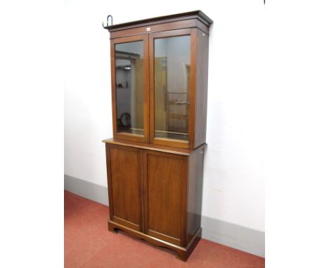 A XX Century Mahogany Bookcase, with stepped cornice and twin glazed doors, the base with panelled doors, on bracket feet, 19