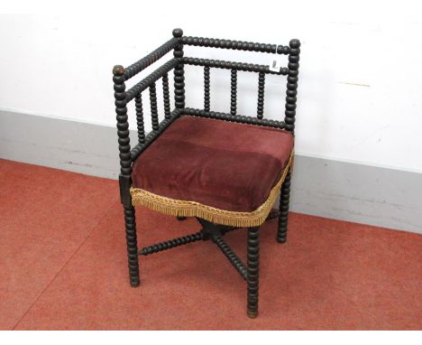 A XIX Century Ebonised Bobbin Turned Corner Chair, with upholstered seat and 'X' stretcher.