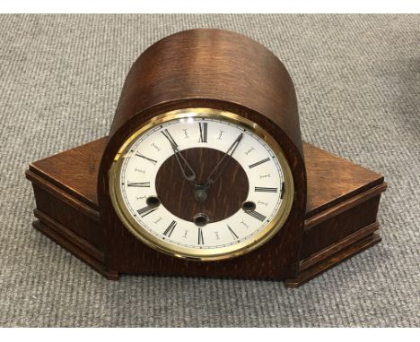 An Art Deco oak cased mantel clock with pendulum and key