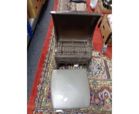 A vintage metal heater and a small typewriter 