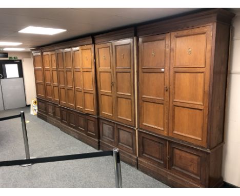 An impressive oak gun-room cabinet, the nine panel doors with breakfront on cupboard base, standing height 229 cm and length 