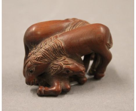 A Japanese carved wood netsuke in the form of horses. 4.5 cm long.