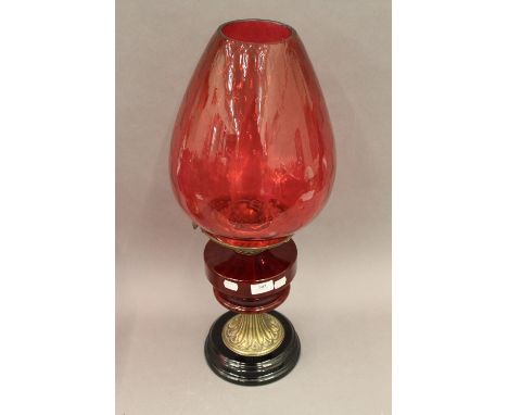 A Victorian oil lamp with ruby glass reservoir and cranberry glass shade. 63 cm high.
