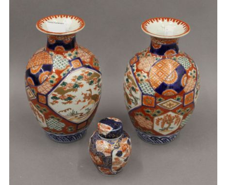 A pair of 19th century Japanese Imari decorated vases together with an Imari tea caddy. The former 23 cm high.