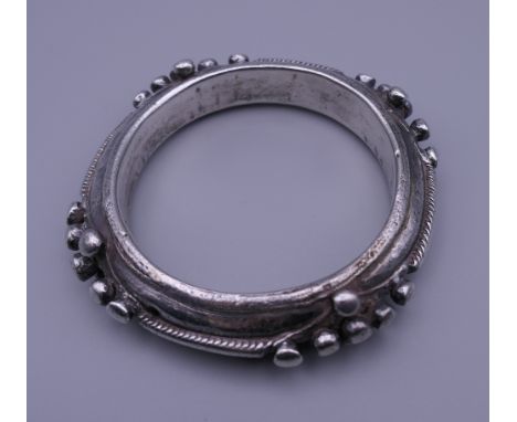 An Eastern white metal bangle. 9 cm diameter. 