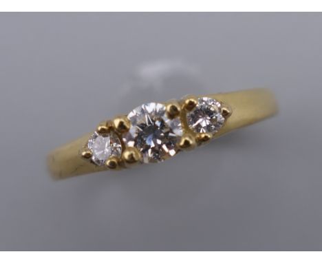 A vintage 18 ct gold diamond trilogy ring. Centre stone approximately 0.20 carat. Ring size K/L.