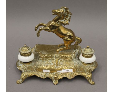 A porcelain mounted brass inkwell surmounted with a horse. 23.5 cm high.