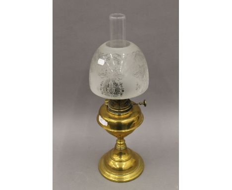 A Victorian brass oil lamp with etched glass shade. 60 cm high.