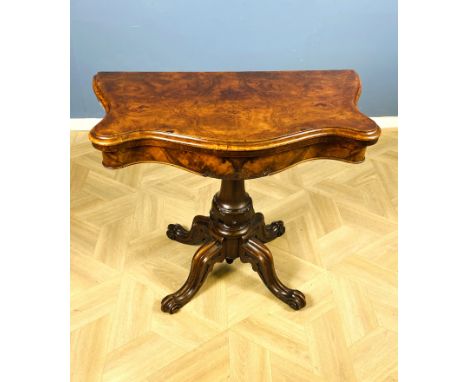 A Victorian burr walnut serpentine card table with a cross grain walnut top moulding and a swivel top and interior baize play