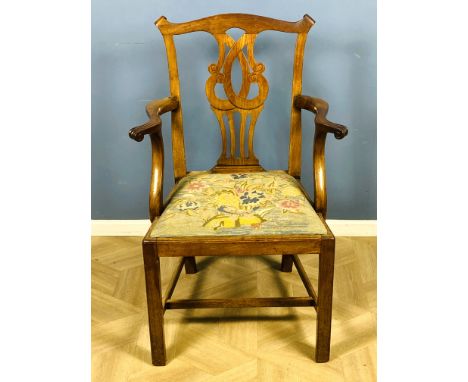 A 19th century mahogany Chippendale style elbow chair with a carved and pierced central back splat, with a needlepoint drop i