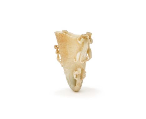 A large and finely carved Chinese pale celadon jade rhyton, gong, 17th-18th century, carved with zoomorphic features includin