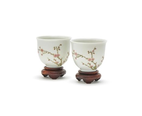 A pair of Chinese Famille Rose wine cups, each painted with flowering prunus blossoms and inscribed on the reverse, the base 