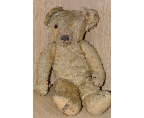 A 1930'S MERRYTHOUGHT GOLDEN PLUSH TEDDY BEAR, one amber and black glass eye (other missing), shaved muzzle with vertically s
