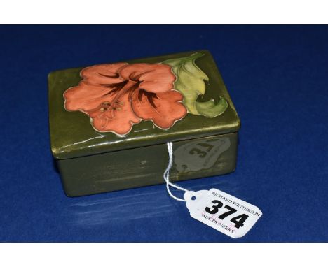 A MOORCROFT POTTERY RECTANGULAR TRINKET BOX AND COVER, decorated in Coral Hibiscus pattern on a green ground, Queen Mary pape