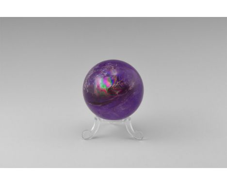 A sphere of dark Brazilian amethyst, with internal features producing a 'rainbow' effect in some areas, with stand. Found Bra