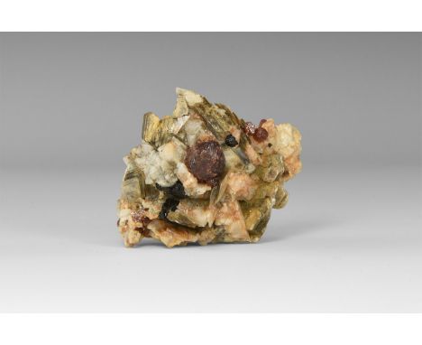 An andradite garnet resting on albite, with accessory muscovite and a number of small andradite garnets, from Pakistan; accom