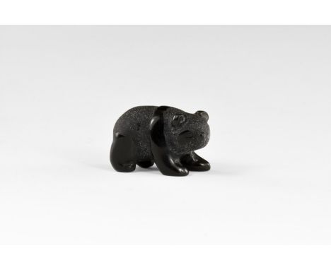 A small but exquisitely detailed carving of a panda, in black onyx, with contrasting texture for light and dark areas. From t
