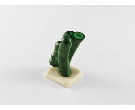 A fine polished stalagmite of malachite mounted on a marble base, with one end sawn and polished to reveal the layering, from