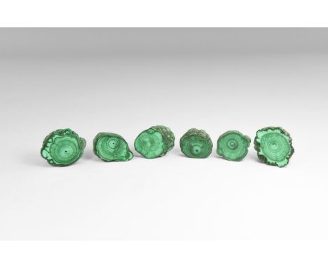 A group of six malachite 'eyes' - sections cut from malachite stalactites, and polished both sides to show the inner, layered