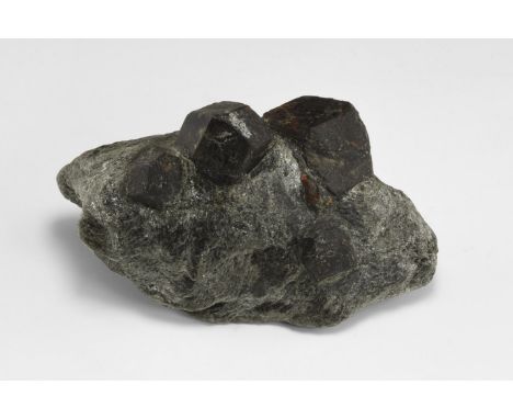 A matrix specimen consisting of two large dodecahedral almandine garnets crystals with three smaller crystals, all on a groun