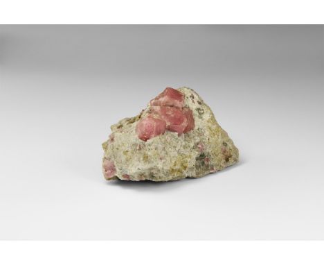 A specimen consisting of four vivid pink grossular garnet crystals in matrix, from Mexico, in old white card tray. From the h