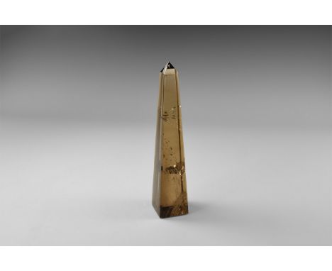 A remarkable obelisk cut from a single, large smoky quartz crystal, with internal veils and reflective surface producing rain