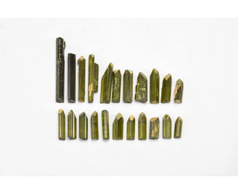 A group of twenty two gem quality green tourmaline crystals, most terminated with mineral overgrowth on termination faces, in