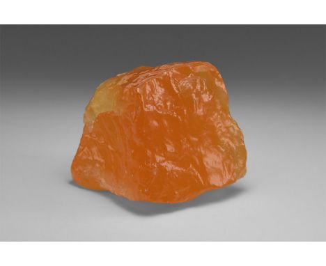 A piece of translucent Mexican calcite with an unusually vibrant orange colour, in old white card tray with label reading: 'O