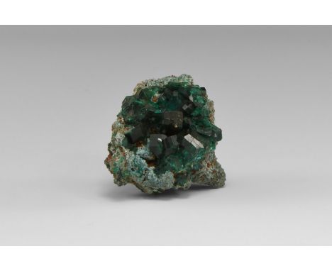 A matrix specimen of dioptase crystals with slightly frosted surfaces, from the classic Tsumeb, Namibia, locality, in old whi