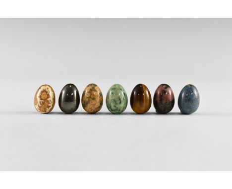 A group of seven gemstone mini-eggs, including sodalite, tiger eye, unakite, hematite, rhodonite, moss agate, and fossil lime