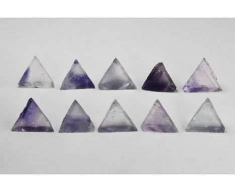 Group of ten clear to purple and lavender triangular cleaved fluorite crystals, some with strong colour-banding, from the Tri