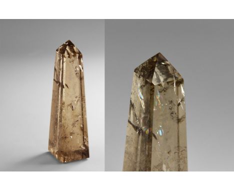 A finely carved obelisk of smoky quartz with a number of interesting internal features dispersing light into rainbow effects.