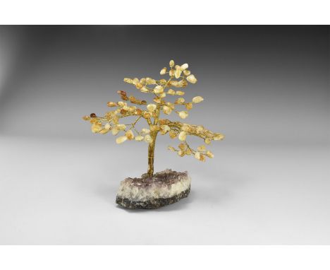 A medium size gemstone tree consisting of a brass trunk and branches tipped with polished citrines, mounted on a section of a