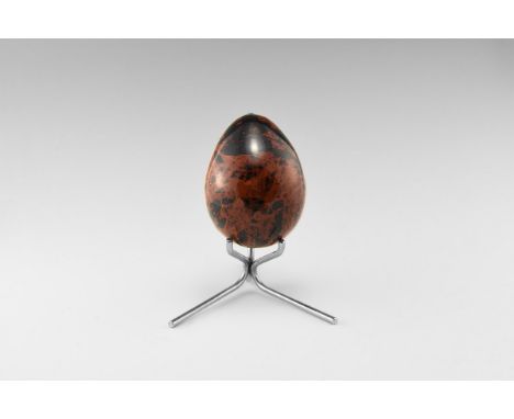 An egg carved in brown and black obsidian with interesting flow patterns intermixing the two colours, with stand. From the hi