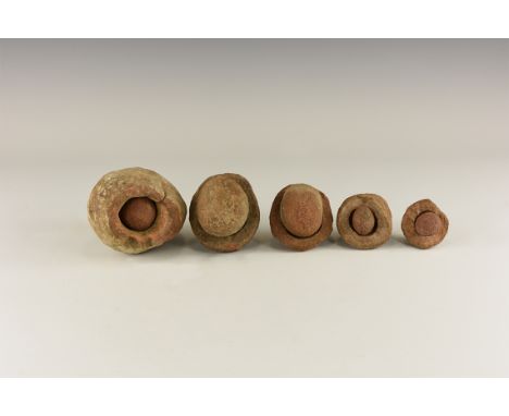 Group of five wind-rounded pebbles with their individual hollowed out 'nests', from the Kalahari Desert region, western Afric