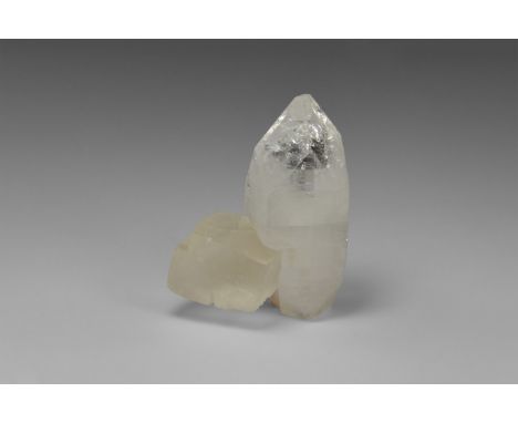 A large single crystal of the zeolite apophyllite with an attached pseudo-cubic calcite crystal from Maharashita, India, in o
