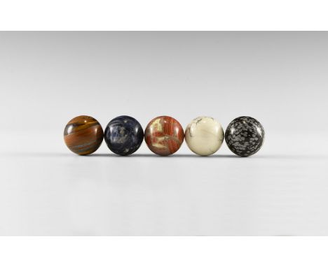 A group consisting of five gemstone spheres, including one each of: tiger iron, brecciated jasper, howlite, sodalite, and sno
