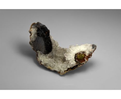 A fine example of radiating hematite crystals on quartz, with two radiating groups and a scatter of single crystals across th
